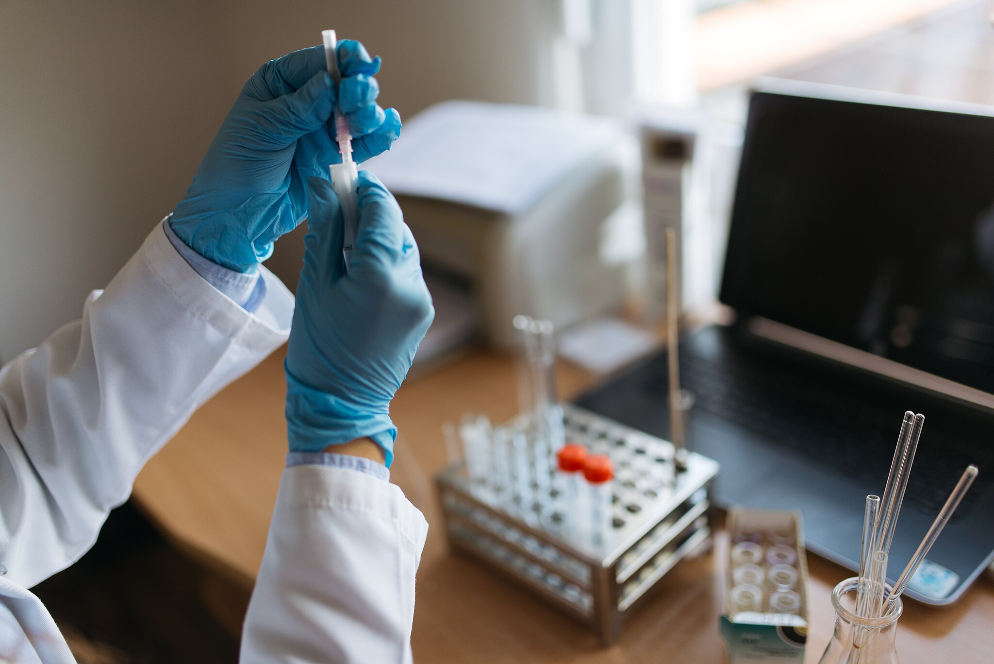 2048px-Testing_vaccine_in_laboratory._Holding_syringe_with_protective_medical_gloves_closeup._51714051263.jpg